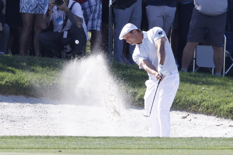 Mar 7, 2021; Orlando, Florida, USA; Bryson DeChambeau hits from a bunker near the fifth green after driving the lake during the final round of the Arnold Palmer Invitational golf tournament at Bay Hill Club & Lodge. Mandatory Credit: Reinhold Matay-USA TODAY Sports