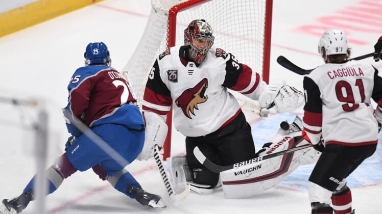 Mar 8, 2021; Denver, Colorado, USA; Arizona Coyotes goaltender Darcy Kuemper (35) makes a pad save on right wing Logan O'Connor (25) in the first period at Ball Arena. Mandatory Credit: Ron Chenoy-USA TODAY Sports