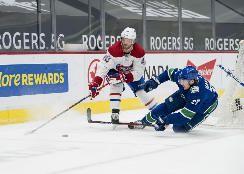 Mar 8, 2021; Vancouver, British Columbia, CAN; Vancouver Canucks defenseman Travis Hamonic (27) checks Montreal Canadiens forward Joel Armia (40) in the second period at Rogers Arena. Mandatory Credit: Bob Frid-USA TODAY Sports