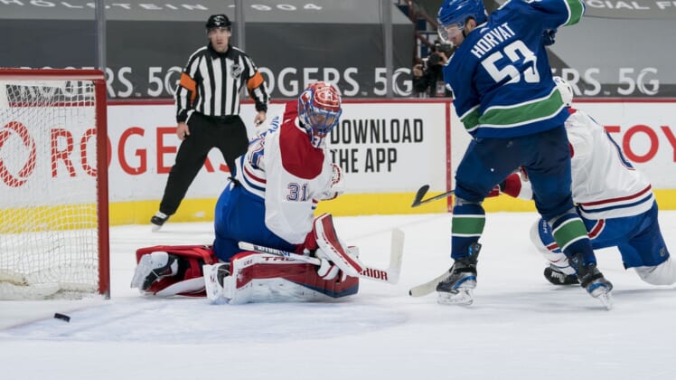 Mar 8, 2021; Vancouver, British Columbia, CAN; Vancouver Canucks forward Bo Horvat (53) and Montreal Canadiens goalie Carey Price (31) watch the rebound in the third period at Rogers Arena. Canucks won 2-1 in an overtime shootout. Mandatory Credit: Bob Frid-USA TODAY Sports
