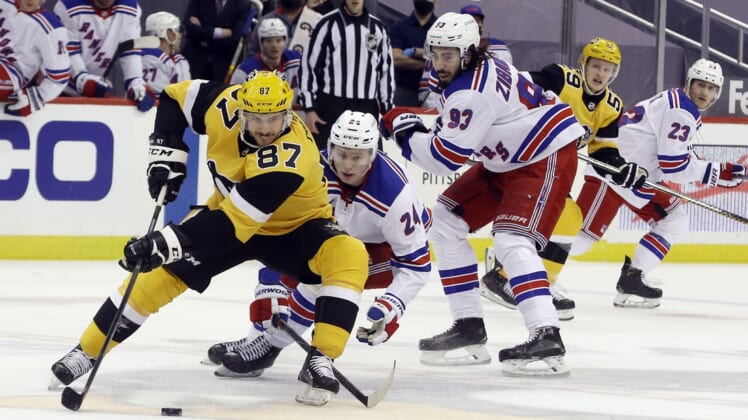 Mar 9, 2021; Pittsburgh, Pennsylvania, USA;  Pittsburgh Penguins center Sidney Crosby (87) handles the puck against New York Rangers right wing Kaapo Kakko (24) and center Mika Zibanejad (93) during the first period at PPG Paints Arena. Mandatory Credit: Charles LeClaire-USA TODAY Sports