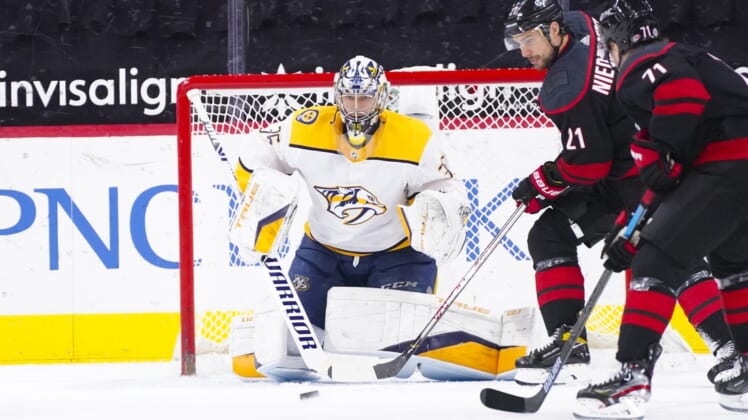 Mar 9, 2021; Raleigh, North Carolina, USA;  Carolina Hurricanes right wing Nino Niederreiter (21) gets ready to tip the shot on Nashville Predators goaltender Pekka Rinne (35) during the first period at PNC Arena. Mandatory Credit: James Guillory-USA TODAY Sports