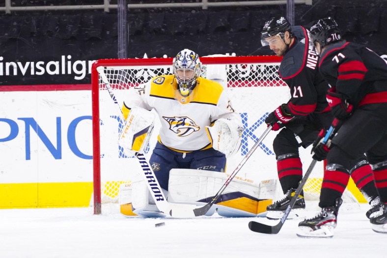 Mar 9, 2021; Raleigh, North Carolina, USA;  Carolina Hurricanes right wing Nino Niederreiter (21) gets ready to tip the shot on Nashville Predators goaltender Pekka Rinne (35) during the first period at PNC Arena. Mandatory Credit: James Guillory-USA TODAY Sports