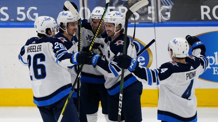 Mar 9, 2021; Toronto, Ontario, CAN; Winnipeg Jets defenseman Josh Morrissey (44) gets congratulated on his goal against the Toronto Maple Leafs during the second period at Scotiabank Arena. Mandatory Credit: John E. Sokolowski-USA TODAY Sports