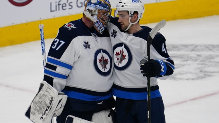 Mar 9, 2021; Toronto, Ontario, CAN; Winnipeg Jets goaltender Connor Hellebuyck (37) and defenseman Neal Pionk (4) celebrate a win over the Toronto Maple Leafs during the third period at Scotiabank Arena. Winnipeg defeated Toronto. Mandatory Credit: John E. Sokolowski-USA TODAY Sports