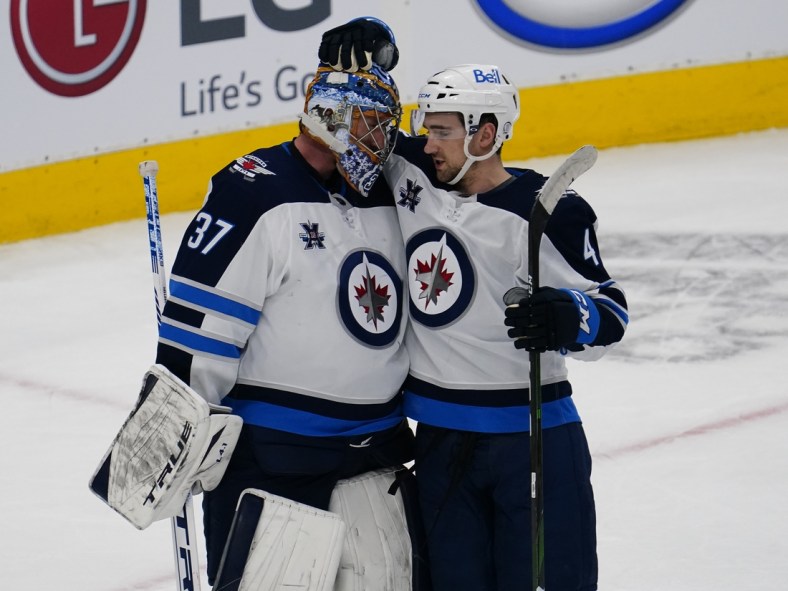 Mar 9, 2021; Toronto, Ontario, CAN; Winnipeg Jets goaltender Connor Hellebuyck (37) and defenseman Neal Pionk (4) celebrate a win over the Toronto Maple Leafs during the third period at Scotiabank Arena. Winnipeg defeated Toronto. Mandatory Credit: John E. Sokolowski-USA TODAY Sports