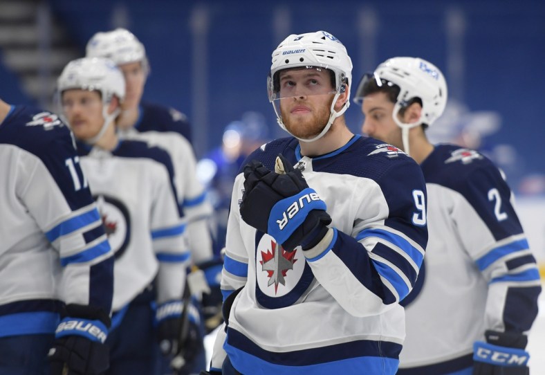 Mar 11, 2021; Toronto, Ontario, CAN;  Winnipeg Jets forward Andrew Copp (9) skates off the ice with teammates after losing 4-3 in overtime to Toronto Maple Leafs at Scotiabank Arena. Mandatory Credit: Dan Hamilton-USA TODAY Sports