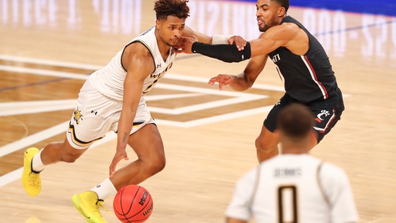 Mar 13, 2021; Fort Worth, TX, USA;  Wichita State Shockers guard Tyson Etienne (1) drives to the basket against Cincinnati Bearcats guard David DeJulius (0) during the second half at Dickies Arena. Mandatory Credit: Ben Ludeman-USA TODAY Sports