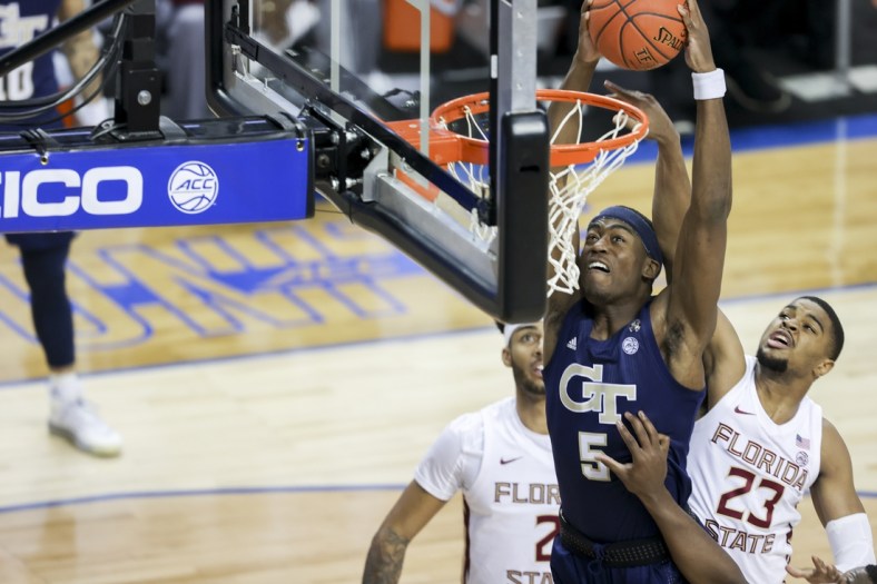 Mar 13, 2021; Greensboro, North Carolina, USA; Georgia Tech Yellow Jackets forward Moses Wright (5) dunks ahead of Florida State Seminoles guard M.J. Walker (23) during the first half in the 2021 ACC tournament championship game at Greensboro Coliseum. Mandatory Credit: Nell Redmond-USA TODAY Sports