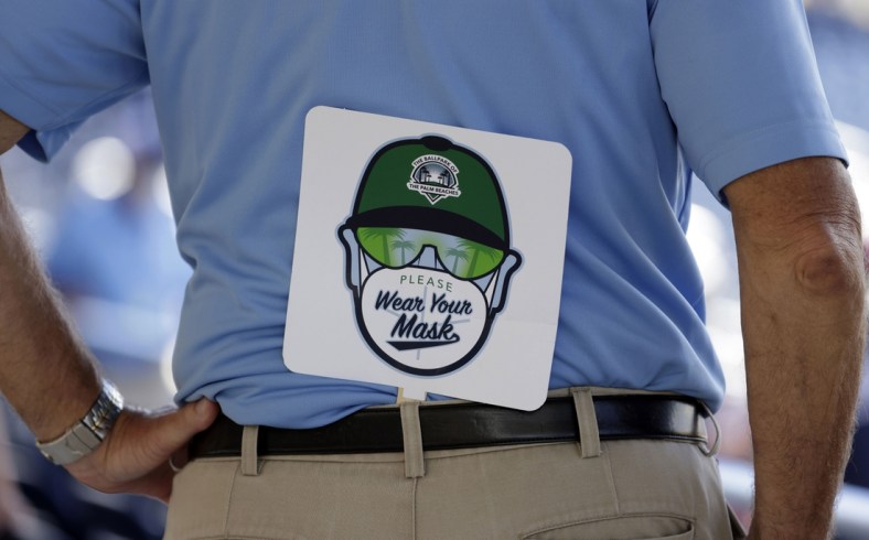 Mar 14, 2021; West Palm Beach, Florida, USA;  A security guard wears his wear your mask sign during the first inning of a spring training game between the Houston Astros and the Washington Nationals at FITTEAM Ballpark of the Palm Beaches. Mandatory Credit: Rhona Wise-USA TODAY Sports