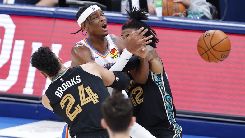 Mar 14, 2021; Oklahoma City, Oklahoma, USA; Oklahoma City Thunder guard Shai Gilgeous-Alexander (C) is fouled while defended by Memphis Grizzlies guard Dillon Brooks (24) and guard Ja Morant (12) during the second half at Chesapeake Energy Arena. Mandatory Credit: Alonzo Adams-USA TODAY Sports