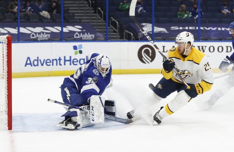 Mar 15, 2021; Tampa, Florida, USA;  Nashville Predators right wing Mathieu Olivier (25) shoots on Tampa Bay Lightning goaltender Curtis McElhinney (35) as he makes a save during the second period at Amalie Arena. Mandatory Credit: Kim Klement-USA TODAY Sports