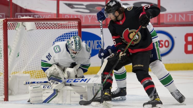 Mar 15, 2021; Ottawa, Ontario, CAN; Vancouver Canucks goalie Thatcher Demko (35) makes a save in front of Ottawa Senators center Colin White (36) in the second period at the Canadian Tire Centre. Mandatory Credit: Marc DesRosiers-USA TODAY Sports