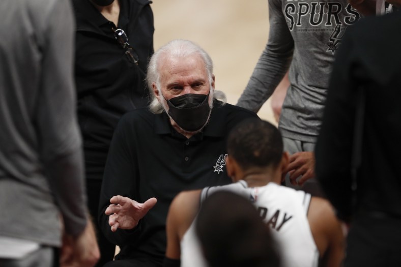 Mar 15, 2021; Detroit, Michigan, USA; San Antonio Spurs head coach Gregg Popovich talks to guard Dejounte Murray (5) in a huddle during the third quarter against the Detroit Pistons at Little Caesars Arena. Mandatory Credit: Raj Mehta-USA TODAY Sports