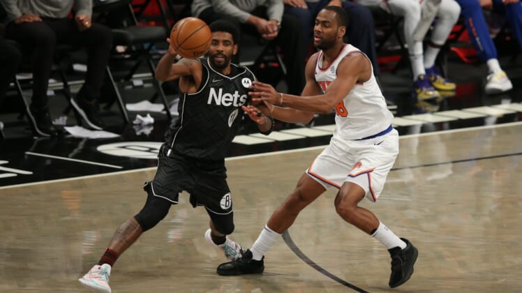 Mar 15, 2021; Brooklyn, New York, USA; Brooklyn Nets point guard Kyrie Irving (11) plays the ball against New York Knicks shooting guard Alec Burks (18) during the fourth quarter at Barclays Center. Mandatory Credit: Brad Penner-USA TODAY Sports