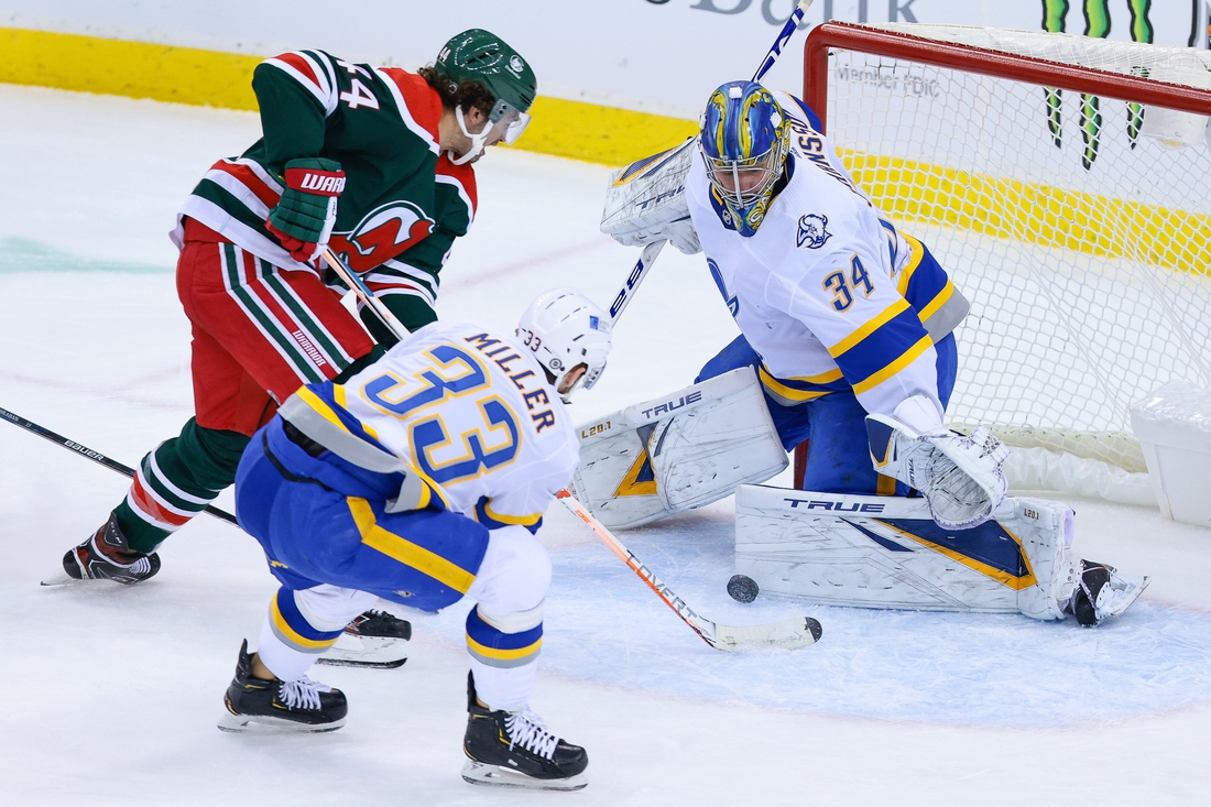 Mar 16, 2021; Newark, New Jersey, USA; Buffalo Sabres goaltender Jonas Johansson (34) makes a save against New Jersey Devils left wing Miles Wood (44) as Buffalo defenseman Colin Miller (33) assists during the second period at Prudential Center. Mandatory Credit: Vincent Carchietta-USA TODAY Sports