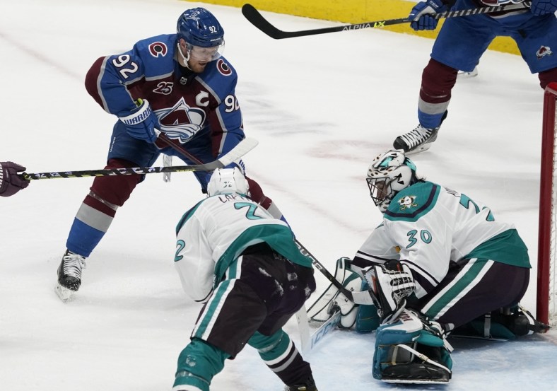 Mar 16, 2021; Denver, Colorado, USA; Colorado Avalanche left wing Gabriel Landeskog (92) shoots the puck against Anaheim Ducks defenseman Jacob Larsson (32) and goaltender Ryan Miller (30) in the second period at Ball Arena. Mandatory Credit: Ron Chenoy-USA TODAY Sports