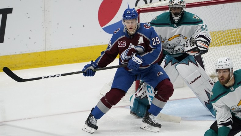 Mar 16, 2021; Denver, Colorado, USA; Colorado Avalanche center Nathan MacKinnon (29) looks for a pass infant of Anaheim Ducks goaltender Ryan Miller (30) in the third period at Ball Arena. Mandatory Credit: Ron Chenoy-USA TODAY Sports