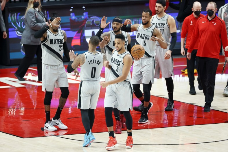 Mar 16, 2021; Portland, Oregon, USA; Portland Trail Blazers point guard Damian Lillard (0) celebrate with teammates after a 125-124 victory over the New Orleans Pelicans at Moda Center. Mandatory Credit: Soobum Im-USA TODAY Sports