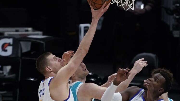 Mar 17, 2021; Denver, Colorado, USA; Denver Nuggets center Nikola Jokic (15) pulls rebound away from Charlotte Hornets center Cody Zeller (40) in the first quarter at Ball Arena. Mandatory Credit: Ron Chenoy-USA TODAY Sports