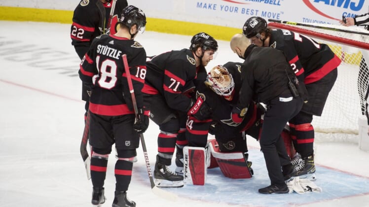 Mar 17, 2021; Ottawa, Ontario, CAN; Ottawa Senators goalie Joey Daccord (34) is helped off the ice after getting injured in the third period against the Vancouver Canucks  at the Canadian Tire Centre. Mandatory Credit: Marc DesRosiers-USA TODAY Sports