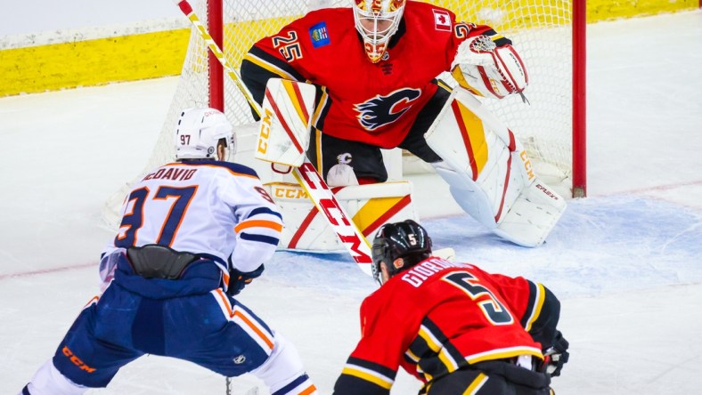 Mar 17, 2021; Calgary, Alberta, CAN; Calgary Flames goaltender Jacob Markstrom (25) guards his net against Edmonton Oilers center Connor McDavid (97) during the second period at Scotiabank Saddledome. Mandatory Credit: Sergei Belski-USA TODAY Sports