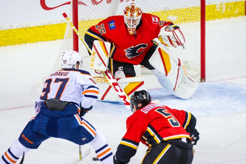 Mar 17, 2021; Calgary, Alberta, CAN; Calgary Flames goaltender Jacob Markstrom (25) guards his net against Edmonton Oilers center Connor McDavid (97) during the second period at Scotiabank Saddledome. Mandatory Credit: Sergei Belski-USA TODAY Sports