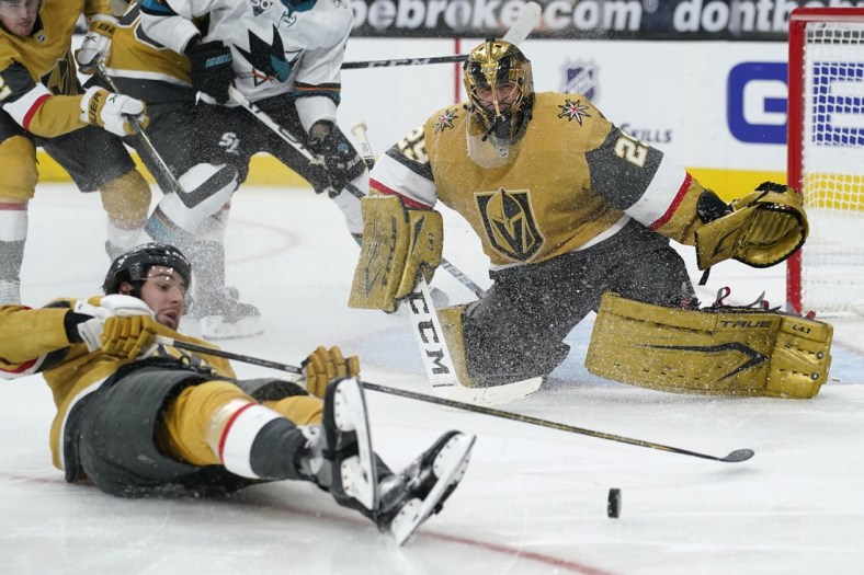Mar 17, 2021; Las Vegas, Nevada, USA; Vegas Golden Knights defenseman Nicolas Hague (14) slides across the ice after Vegas goaltender Marc-Andre Fleury (29) blocked a shot by the San Jose Sharks during the third period at T-Mobile Arena. Mandatory Credit:  John Locher/POOL PHOTOS-USA TODAY Sports