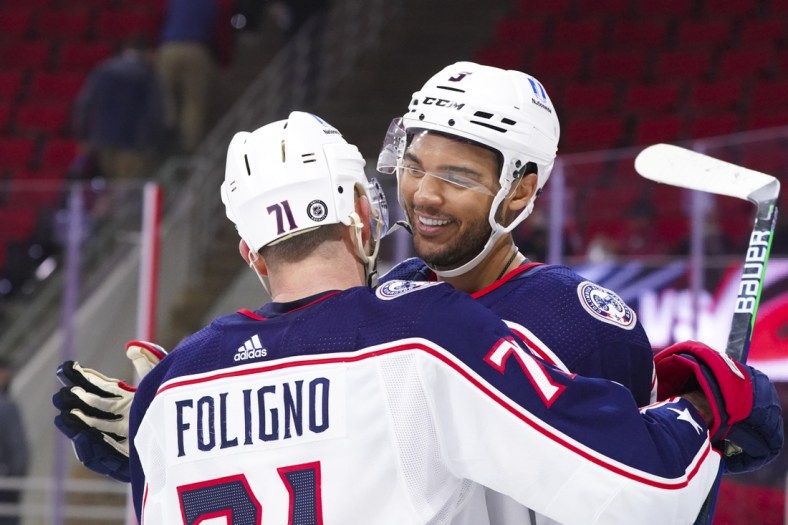 Mar 18, 2021; Raleigh, North Carolina, USA;  Columbus Blue Jackets defenseman Seth Jones (3) is congratulated by left wing Nick Foligno (71) after his game winning overtime goal against the Carolina Hurricanes at PNC Arena. Mandatory Credit: James Guillory-USA TODAY Sports