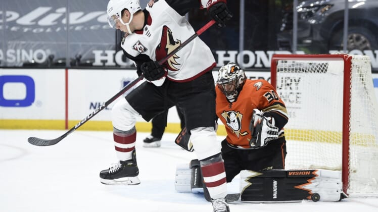 Mar 18, 2021; Anaheim, California, USA; Arizona Coyotes center Tyler Pitlick (17) screens a shot as Anaheim Ducks goalie Ryan Miller (30) makes a save during the second period at Honda Center. Mandatory Credit: Kelvin Kuo-USA TODAY Sports
