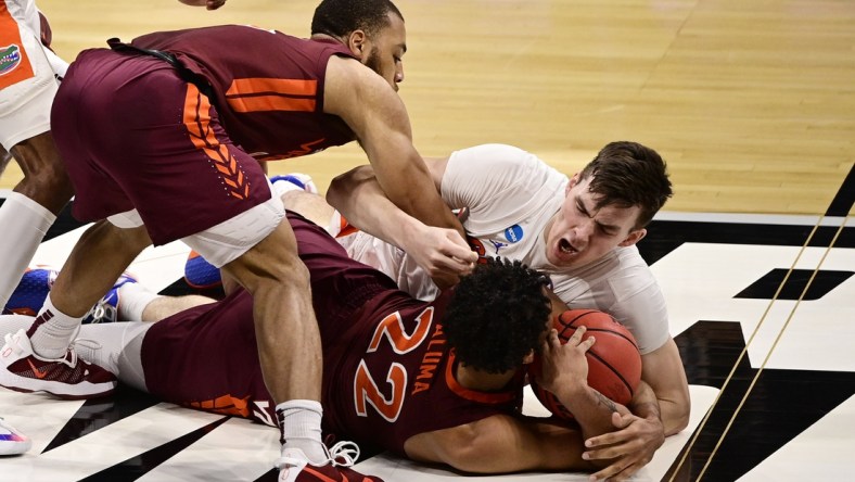 Mar 19, 2021; Indianapolis, Indiana, USA; Florida Gators forward Colin Castleton (12) dives for a loose ball against Virginia Tech Hokies forward Keve Aluma (22) during the first round of the 2021 NCAA Tournament at Hinkle Fieldhouse. Mandatory Credit: Marc Lebryk-USA TODAY Sports