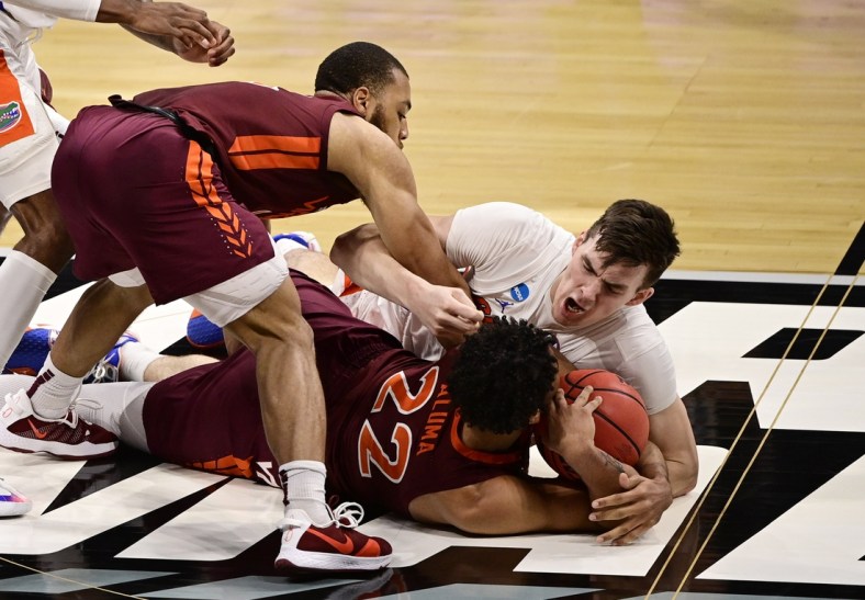 Mar 19, 2021; Indianapolis, Indiana, USA; Florida Gators forward Colin Castleton (12) dives for a loose ball against Virginia Tech Hokies forward Keve Aluma (22) during the first round of the 2021 NCAA Tournament at Hinkle Fieldhouse. Mandatory Credit: Marc Lebryk-USA TODAY Sports