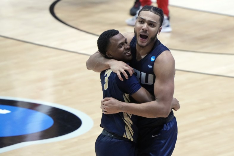 Mar 19, 2021; West Lafayette, Indiana, USA; Oral Roberts Golden Eagles guard Max Abmas (3) and forward Kevin Obanor (0) celebrate after an overtime victory over the Ohio State Buckeyes in the first round of the 2021 NCAA Tournament at Mackey Arena. Mandatory Credit: Mike Dinovo-USA TODAY Sports
