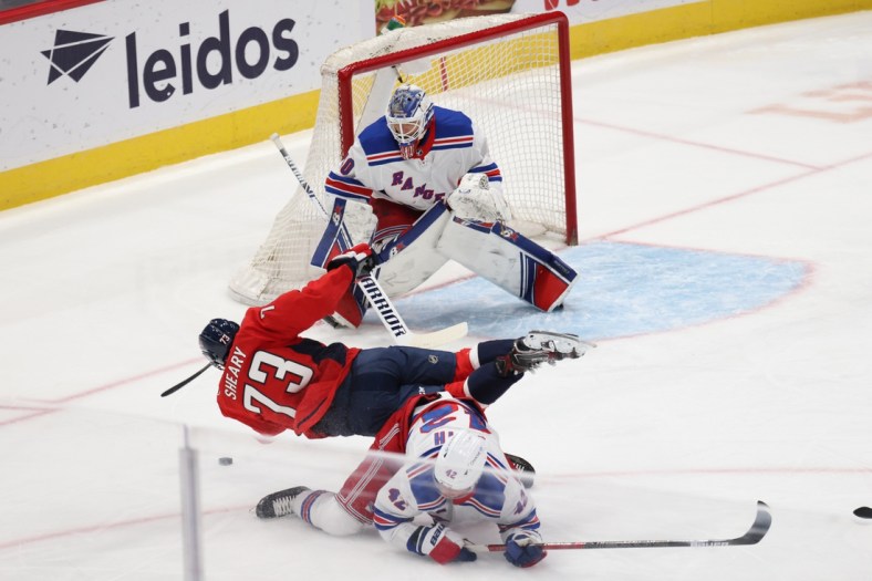 Mar 19, 2021; Washington, District of Columbia, USA; Washington Capitals left wing Conor Sheary (73) is checked by New York Rangers defenseman Brendan Smith (42) while attempting a shot on Rangers goaltender Alexandar Georgiev (40) in the first period at Capital One Arena. Mandatory Credit: Geoff Burke-USA TODAY Sports