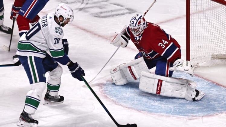 Mar 19, 2021; Montreal, Quebec, CAN; Vancouver Canucks center Brandon Sutter (20) shots the puck against Montreal Canadiens goaltender Jake Allen (34) during the first period at Bell Centre. Mandatory Credit: Jean-Yves Ahern-USA TODAY Sports