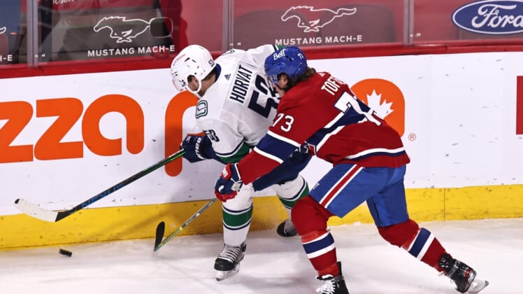 Mar 19, 2021; Montreal, Quebec, CAN; Vancouver Canucks center Bo Horvat (53) and Montreal Canadiens right wing Tyler Toffoli (73) battle for the puck during the first period at Bell Centre. Mandatory Credit: Jean-Yves Ahern-USA TODAY Sports