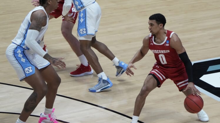 Mar 19, 2021; West Lafayette, Indiana, USA; Wisconsin Badgers guard D'Mitrik Trice (0) dribbles the ball upcourt against North Carolina Tar Heels forward Armando Bacot (left) during the second half in the first round of the 2021 NCAA Tournament at Mackey Arena. Mandatory Credit: Mike Dinovo-USA TODAY Sports