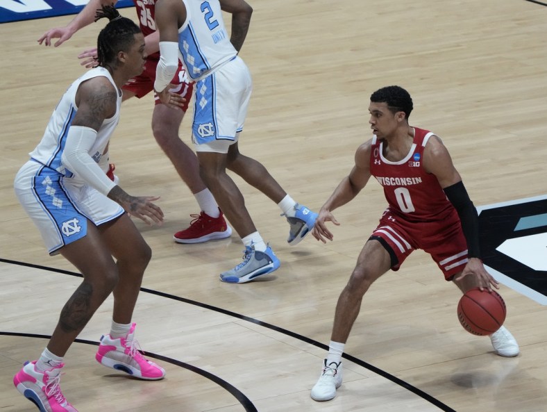 Mar 19, 2021; West Lafayette, Indiana, USA; Wisconsin Badgers guard D'Mitrik Trice (0) dribbles the ball upcourt against North Carolina Tar Heels forward Armando Bacot (left) during the second half in the first round of the 2021 NCAA Tournament at Mackey Arena. Mandatory Credit: Mike Dinovo-USA TODAY Sports