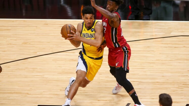 Mar 19, 2021; Miami, Florida, USA; Indiana Pacers guard Malcolm Brogdon (7) controls the basketball around Miami Heat forward Jimmy Butler (22) during the first quarter at American Airlines Arena. Mandatory Credit: Sam Navarro-USA TODAY Sports