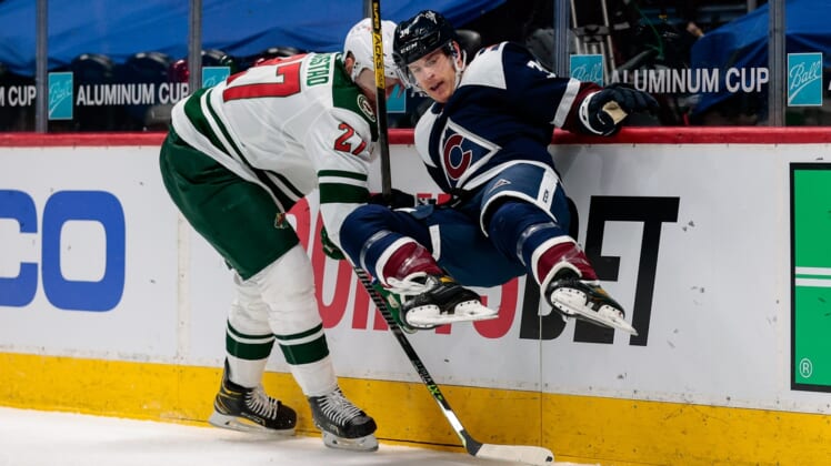Mar 20, 2021; Denver, Colorado, USA; Colorado Avalanche defenseman Jacob MacDonald (34) gets tripped up with Minnesota Wild center Nick Bjugstad (27) in the first period at Ball Arena. Mandatory Credit: Isaiah J. Downing-USA TODAY Sports