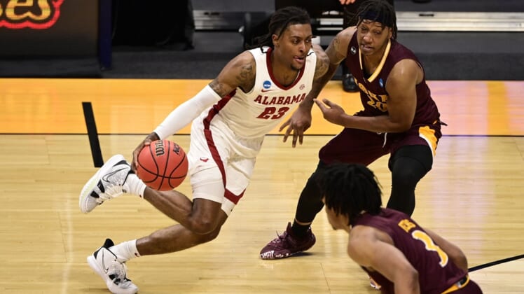 Mar 20, 2021; Indianapolis, Indiana, USA; Alabama Crimson Tide guard John Petty Jr. (23) dribbles against Iona Gaels guard Isaiah Ross (20) during the first round of the 2021 NCAA Tournament at Hinkle Fieldhouse. Mandatory Credit: Marc Lebryk-USA TODAY Sports