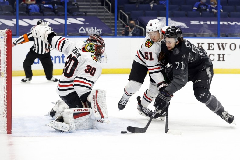 Mar 20, 2021; Tampa, Florida, USA;Tampa Bay Lightning center Anthony Cirelli (71) shoots as Chicago Blackhawks defenseman Ian Mitchell (51) and Chicago Blackhawks goaltender Malcolm Subban (30) defend during the first period at Amalie Arena. Mandatory Credit: Kim Klement-USA TODAY Sports