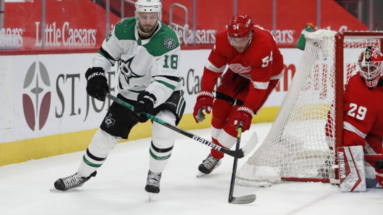 Mar 20, 2021; Detroit, Michigan, USA; Dallas Stars center Jason Dickinson (18) passes the puck against Detroit Red Wings right wing Bobby Ryan (54) during the first period at Little Caesars Arena. Mandatory Credit: Raj Mehta-USA TODAY Sports