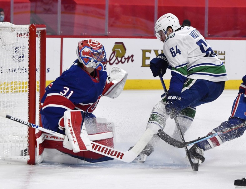 Mar 20, 2021; Montreal, Quebec, CAN; Montreal Canadiens goalie Carey Price (31) stops Vancouver Canucks forward Tyler Motte (64) during the first period at the Bell Centre. Mandatory Credit: Eric Bolte-USA TODAY Sports