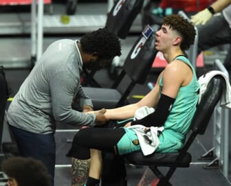 Mar 20, 2021; Los Angeles, California, USA;  Charlotte Hornets team trainer checks the wrist of guard LaMelo Ball (2) in the second half of the game against the Los Angeles Clippers at Staples Center. Mandatory Credit: Jayne Kamin-Oncea-USA TODAY Sports