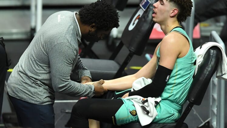 Mar 20, 2021; Los Angeles, California, USA;  Charlotte Hornets team trainer checks the wrist of guard LaMelo Ball (2) in the second half of the game against the Los Angeles Clippers at Staples Center. Mandatory Credit: Jayne Kamin-Oncea-USA TODAY Sports