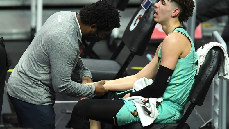 Mar 20, 2021; Los Angeles, California, USA;  Charlotte Hornets team trainer checks the wrist of guard LaMelo Ball (2) in the second half of the game against the Los Angeles Clippers at Staples Center. Mandatory Credit: Jayne Kamin-Oncea-USA TODAY Sports