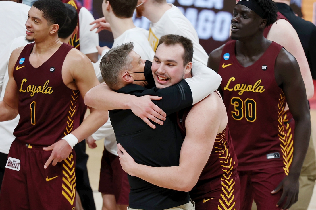 Mar 21, 2021; Indianapolis, Indiana, USA; Loyola Ramblers center Cameron Krutwig (25) hugs head coach Porter Moser after their win over the Illinois Fighting Illini in the second round of the 2021 NCAA Tournament at Bankers Life Fieldhouse. The Loyola Ramblers won 71-58. Mandatory Credit: Trevor Ruszkowski-USA TODAY Sports