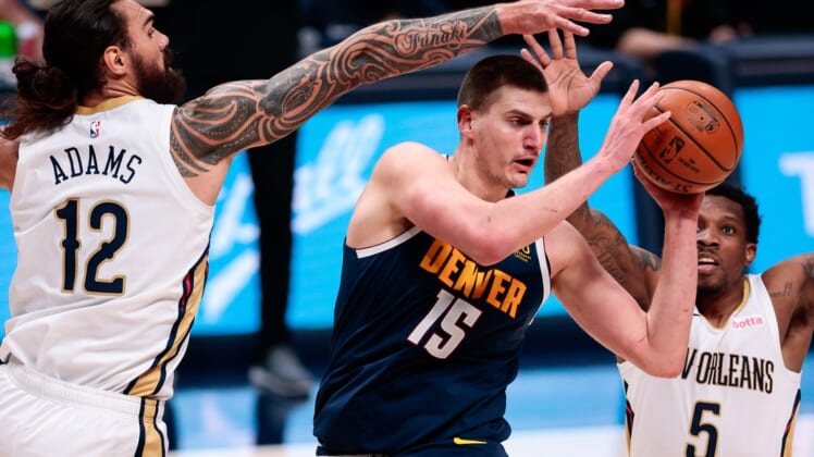 Mar 21, 2021; Denver, Colorado, USA; Denver Nuggets center Nikola Jokic (15) looks to pass the ball under pressure from New Orleans Pelicans center Steven Adams (12) and guard Eric Bledsoe (5) in the second quarter at Ball Arena. Mandatory Credit: Isaiah J. Downing-USA TODAY Sports