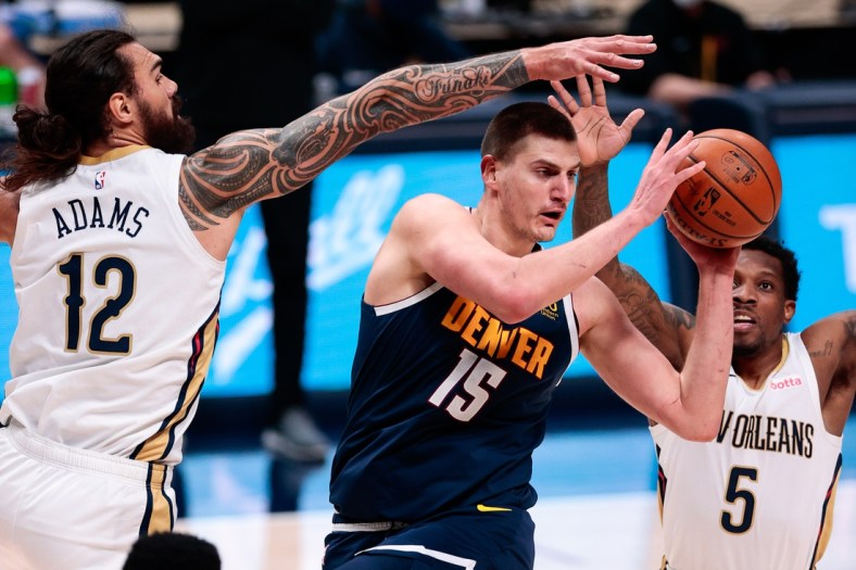 Mar 21, 2021; Denver, Colorado, USA; Denver Nuggets center Nikola Jokic (15) looks to pass the ball under pressure from New Orleans Pelicans center Steven Adams (12) and guard Eric Bledsoe (5) in the second quarter at Ball Arena. Mandatory Credit: Isaiah J. Downing-USA TODAY Sports